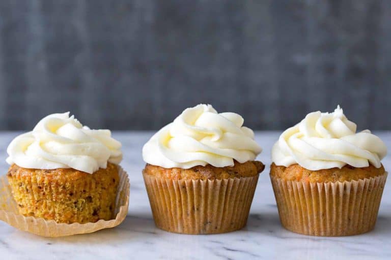 Cream cheese frosting cupcakes on a marble surface with a dark background, showcasing delicious frosted cupcakes perfect for desserts or special occasions.