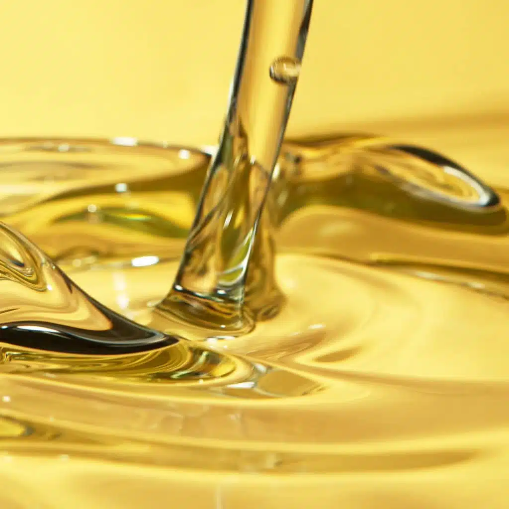 Golden liquid being poured, close-up shot of smooth caramel or honey flowing, high-quality image of glossy, viscous substance for food or product display.